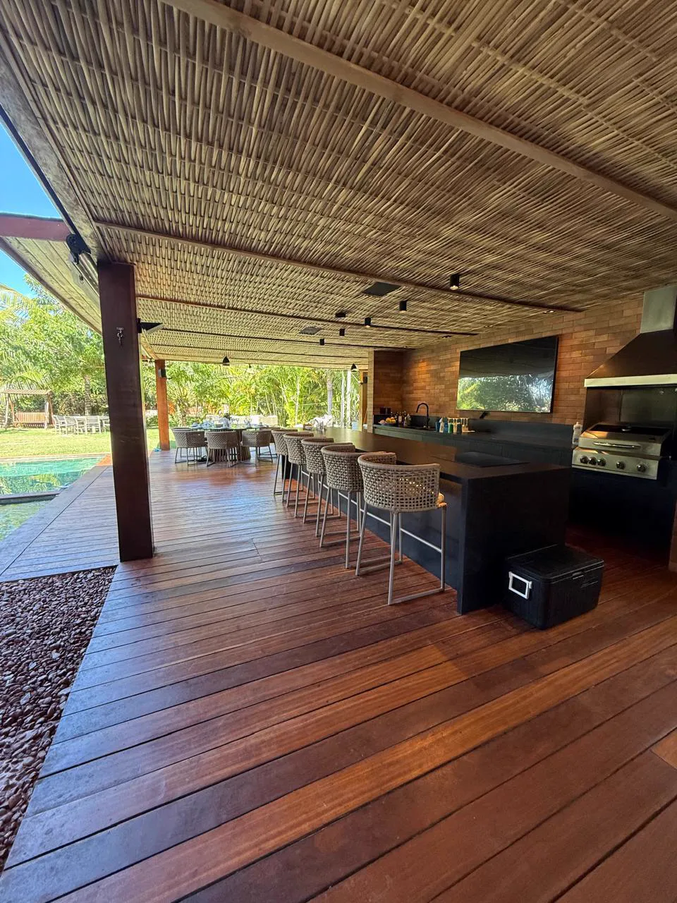 Espaço gourmet com bar, churrasqueira e vista para o jardim