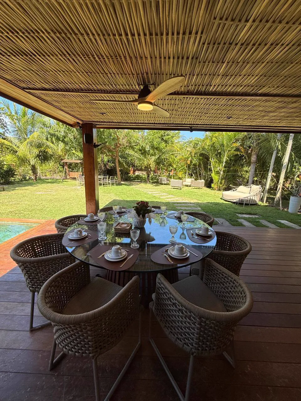 Mesa de jantar no deck, de frente para o jardim e a piscina