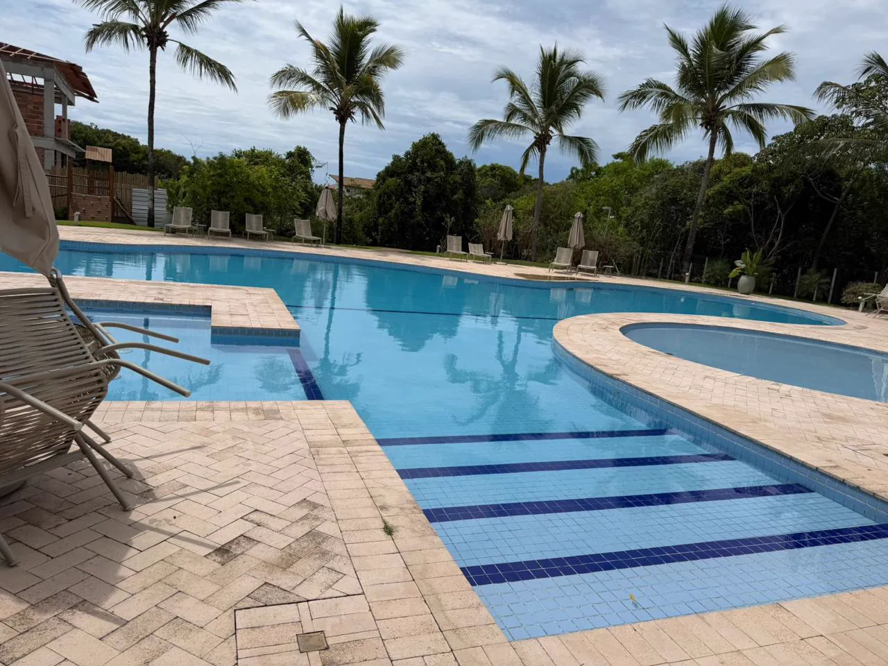 Piscinas comunitárias do condomínio, entre coqueiros