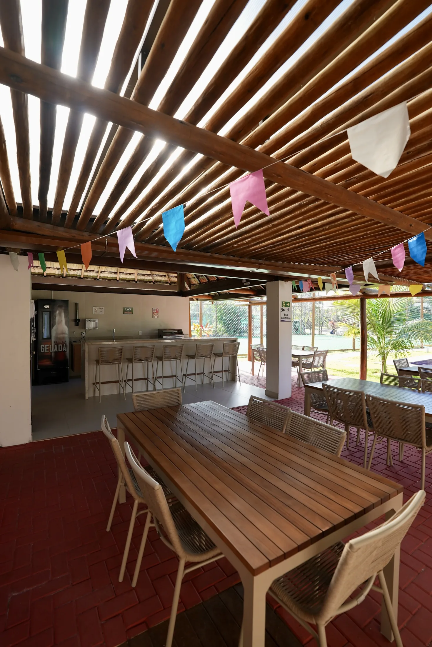 Bar e copa do salão de festas, com mesa de madeira