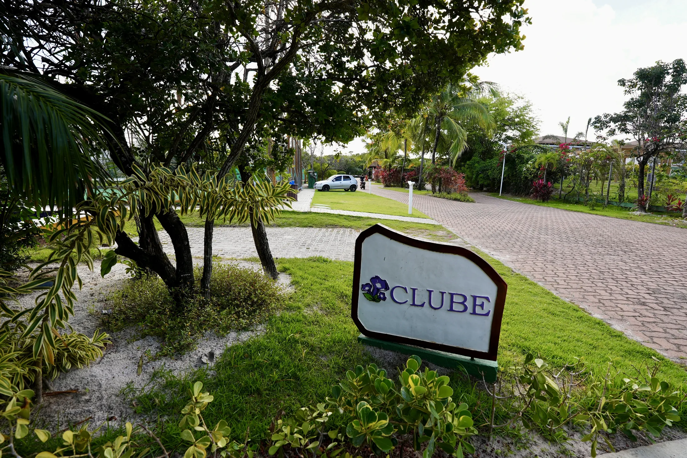 Letreiro do clube do condomínio, entre o jardim e o calçamento