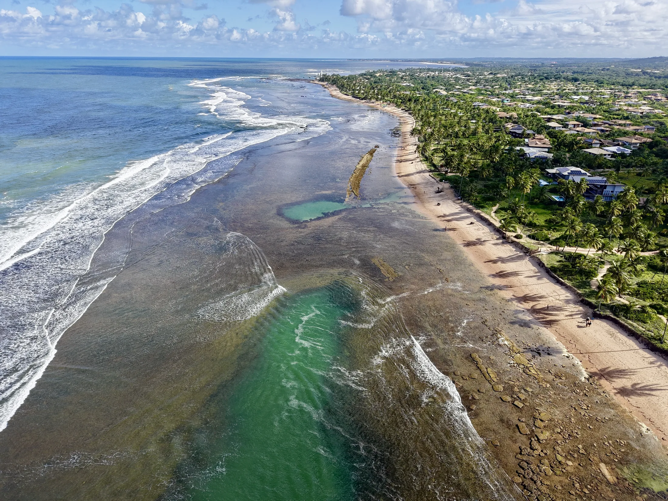 Mar, recifes e a faixa de areia da Praia do Forte vistos do alto