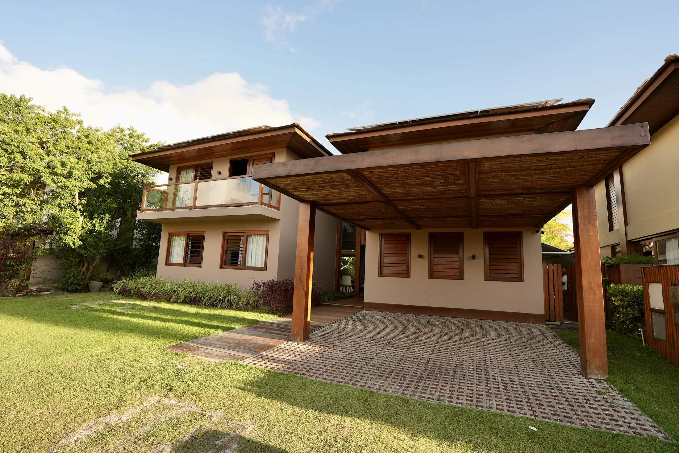Fachada lateral da casa com a garagem coberta e o jardim
