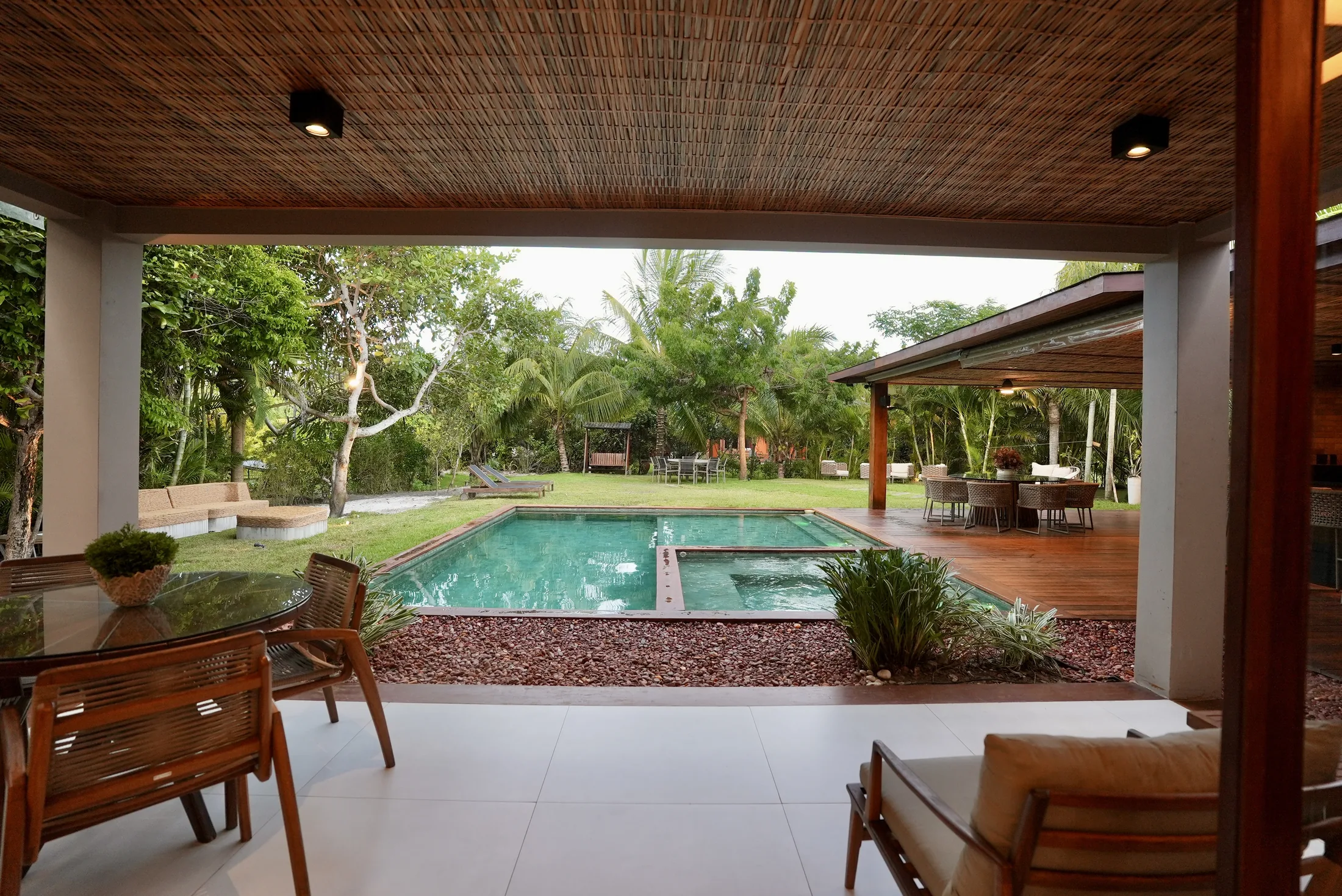 Lounge da varanda com poltronas, de frente para a piscina