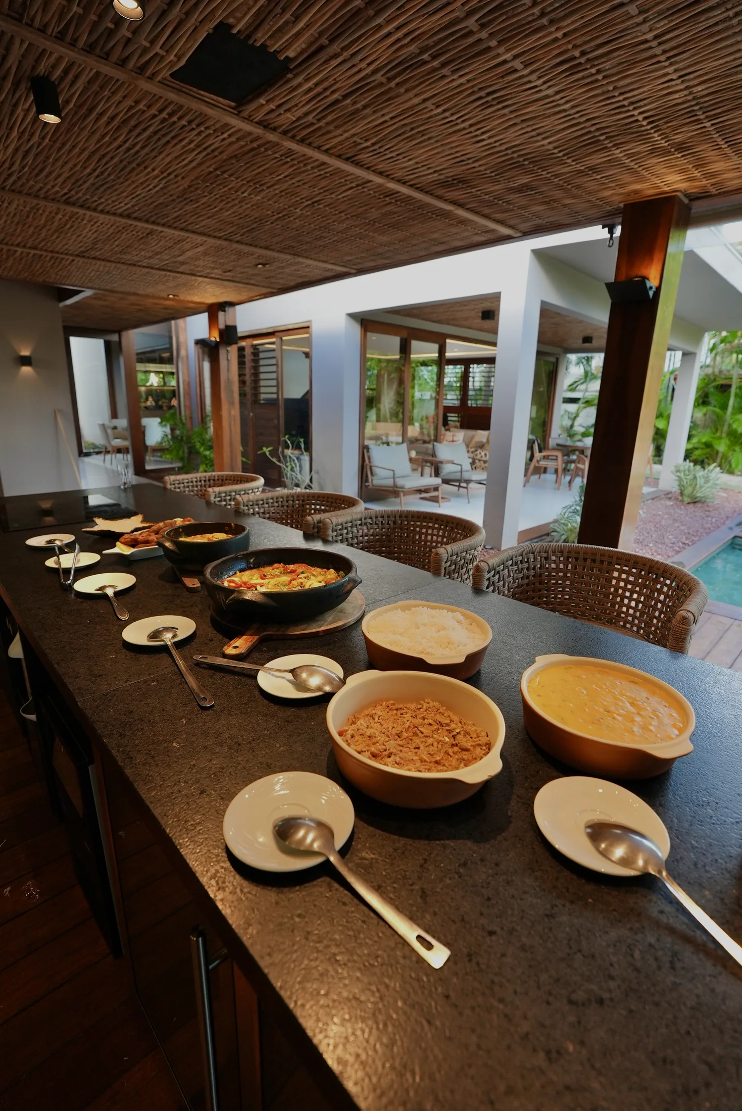 Mesa de jantar posta na varanda, de frente para a piscina